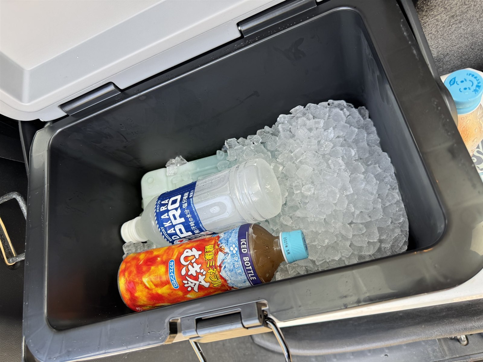 クーラーボックスの庫内に氷と保冷剤、ペットボトル飲料を入れた状態